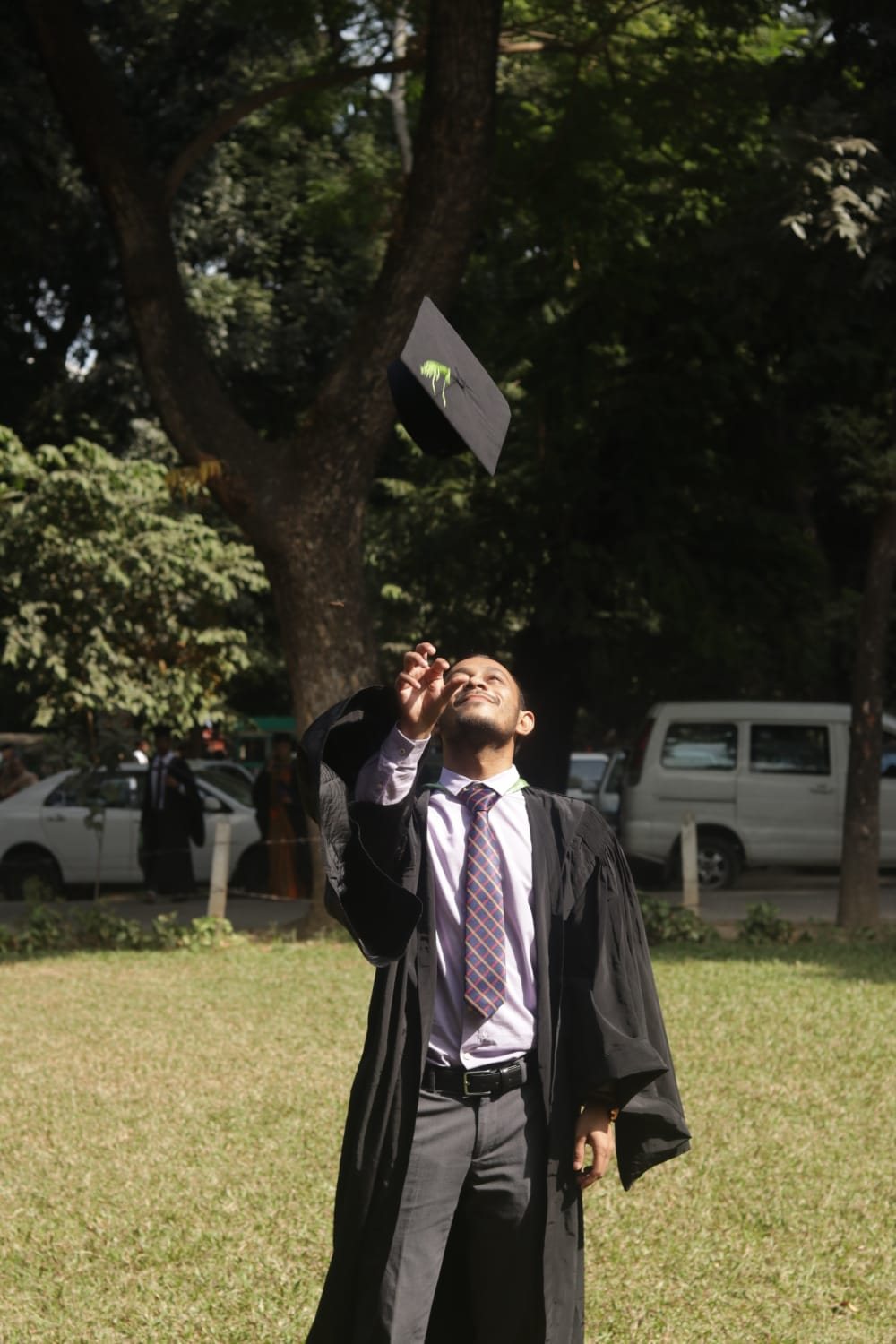 Md Jamil Hasan tossing his graduation cap in the air