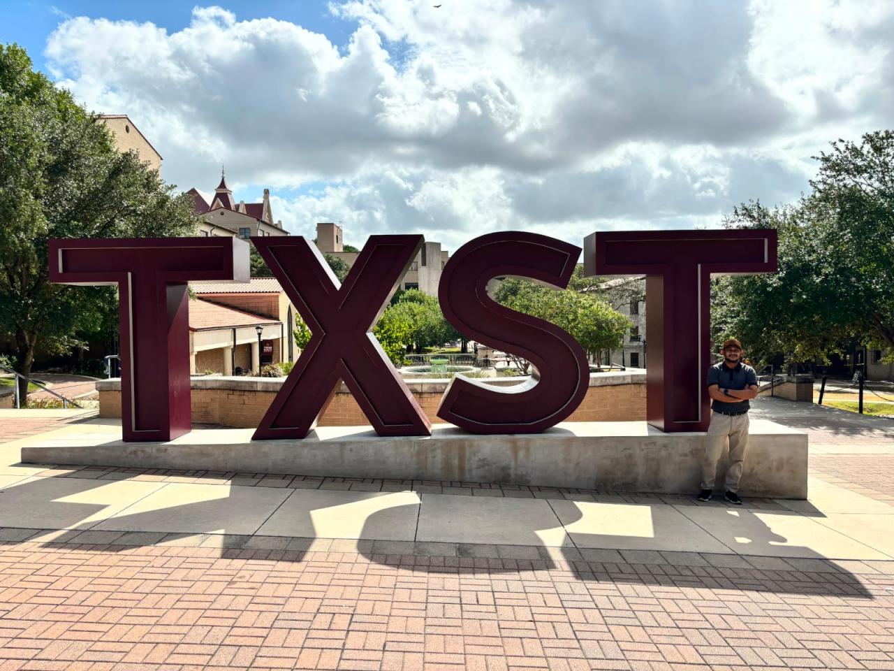 Md Jamil Hasan standing beside the TXST sign at Texas State University